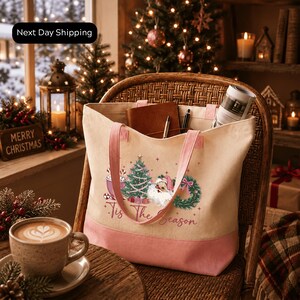 A cozy Christmas scene with a wicker chair, a coffee cup, a tote bag, and a decorated Christmas tree in the background.