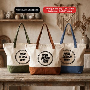 Three tote bags with the text "YOUR DESIGN HERE" printed on them, placed on a wooden table.