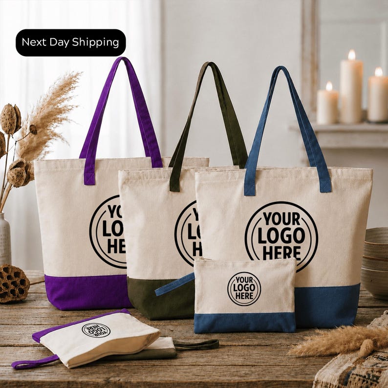 a collection of tote bags and a small bag, all featuring the same logo design. The bags are arranged on a wooden surface, with some candles and dried flowers in the background. The text "Next Day Shipping" is visible, indicating that the items are ready for immediate delivery.