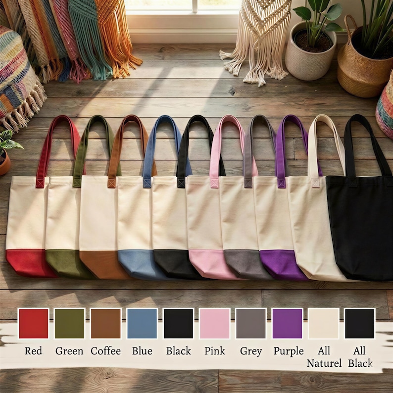 A row of colorful tote bags in various colors, including red, green, blue, black, pink, grey, purple, and natural black, arranged on a wooden floor.