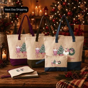 a collection of Christmas-themed tote bags and a small bag set, all displayed on a wooden surface. The tote bags are decorated with festive designs, including Christmas trees, ornaments, and other holiday-related elements. The small bag set is placed next to the tote bags, creating a cohesive display of holiday-themed accessories.