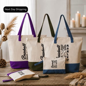 a collection of tote bags and a small bag, all featuring the same design and branding. The bags are arranged on a wooden surface, with a vase of dried flowers and candles in the background. The text "Next Day Shipping" is visible, indicating that the items are ready for immediate delivery.