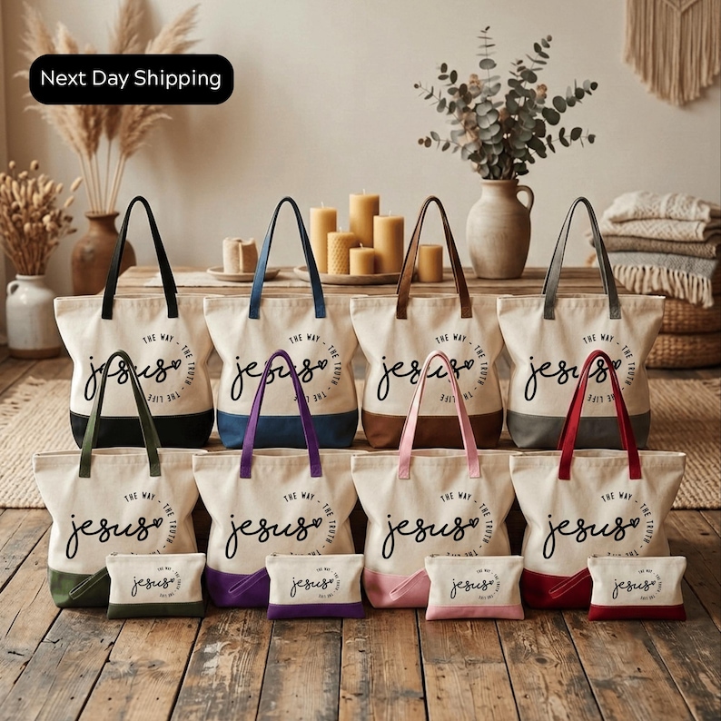 A collection of white tote bags with the text "The Way Jesus" printed on them, arranged on a wooden floor in a room with various decorative elements such as candles, plants, and a woven basket.