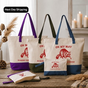 a collection of tote bags and a small bag with the text "On My Way" printed on them, placed on a wooden surface.