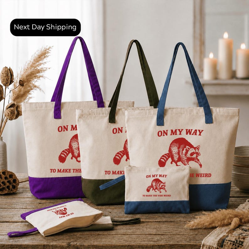 a collection of tote bags and a small bag with the text "On My Way" printed on them, placed on a wooden surface.