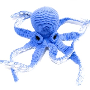 May include: A handmade blue crochet octopus toy with white accents on the tentacles. The octopus has black eyes and is made of soft yarn. This plush toy is suitable for children and adults.