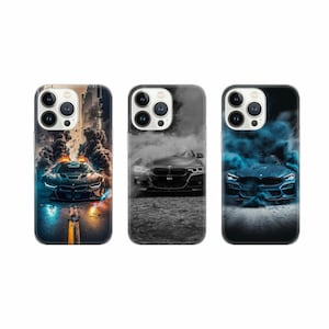 May include: Three iPhone cases with different designs featuring a black and blue sports car with smoke coming from the exhaust. The cases are black, grey, and blue.