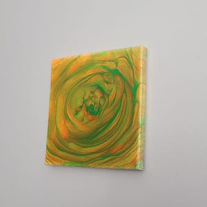 May include: Abstract painting on canvas with swirling green and orange colors. The painting has a circular pattern in the center.