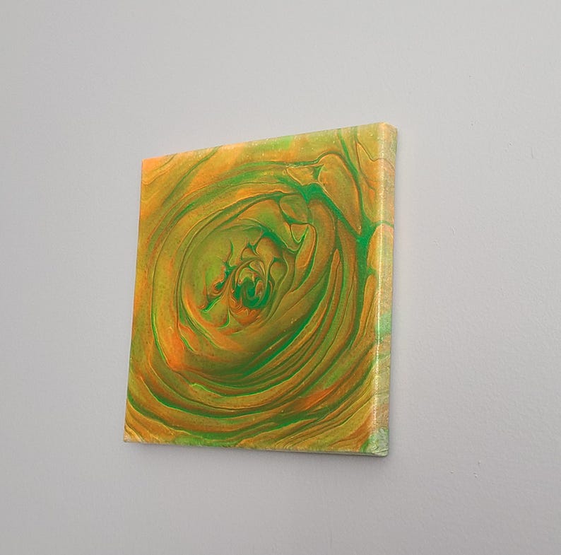 May include: Abstract painting on canvas with swirling green and orange colors. The painting has a circular pattern in the center.