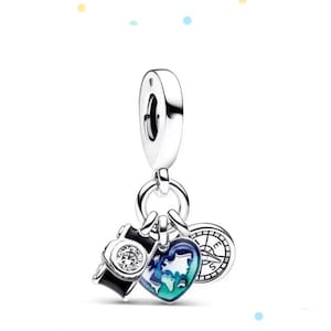 May include: Silver charm with a compass, a heart with a world map, and a black camera with a clear crystal. The charm is designed for a bracelet or necklace.