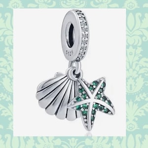 May include: A silver charm with a seashell and a starfish. The starfish is decorated with green crystals. The charm is marked with "S925".