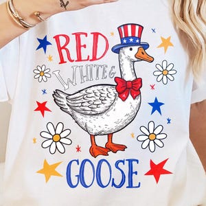 May include: White t-shirt with a red, white, and blue goose wearing a red, white, and blue hat. The text "Red White & Goose" is printed on the shirt.