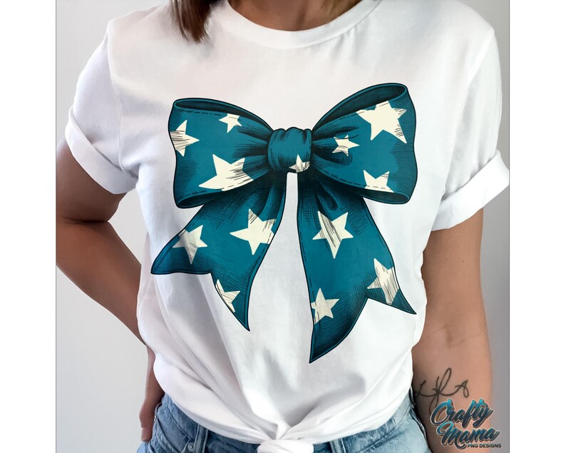May include: White t-shirt with a teal blue bow with white stars printed on it.