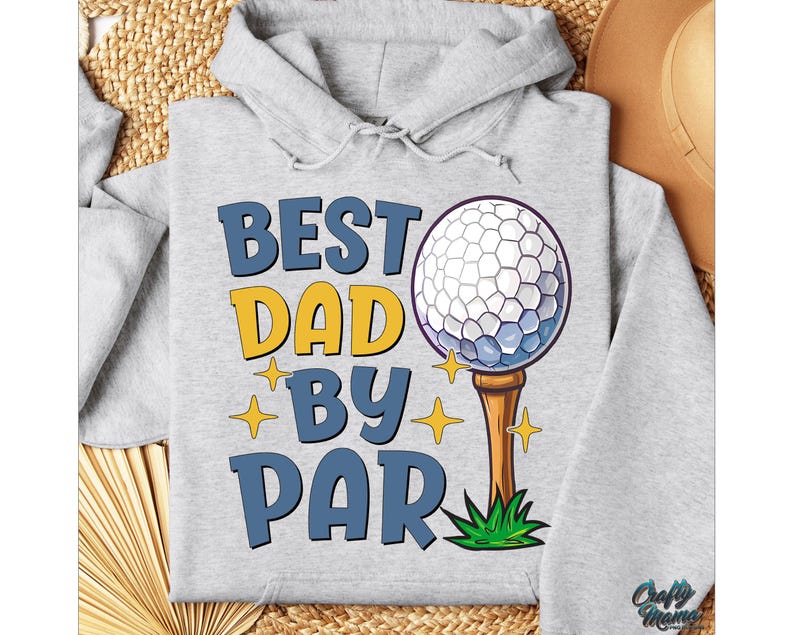 May include: A light grey hoodie featuring the text "BEST DAD BY PAR" in blue and yellow. The design includes a golf ball on a tee and star accents. The hoodie has a drawstring hood.