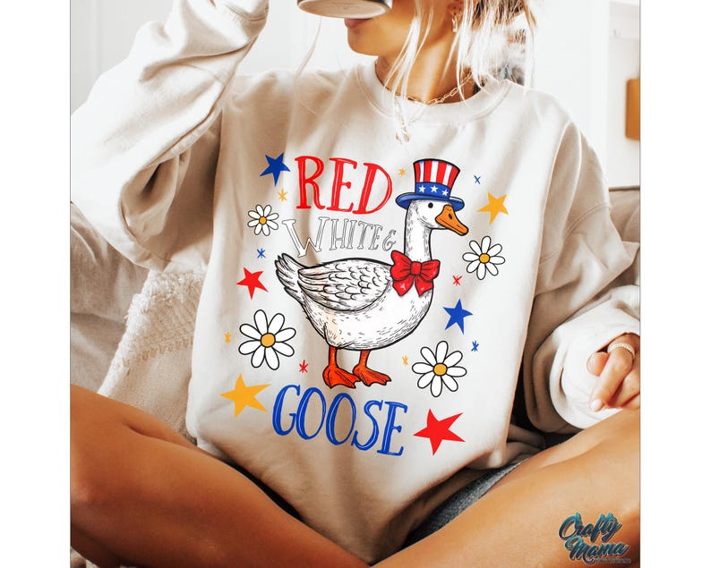 May include: A white sweatshirt with a red, white, and blue goose wearing a red, white, and blue hat. The text "Red White & Goose" is printed on the sweatshirt.