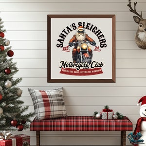 Puede incluir: Una impresi&oacute;n cuadrada en un marco marr&oacute;n con fondo blanco. La impresi&oacute;n presenta una imagen de dibujos animados de Pap&aacute; Noel conduciendo una motocicleta con el texto "Santa's Sleighers est. 24 Motorcycle Club Decking the halls, hitting the highways".