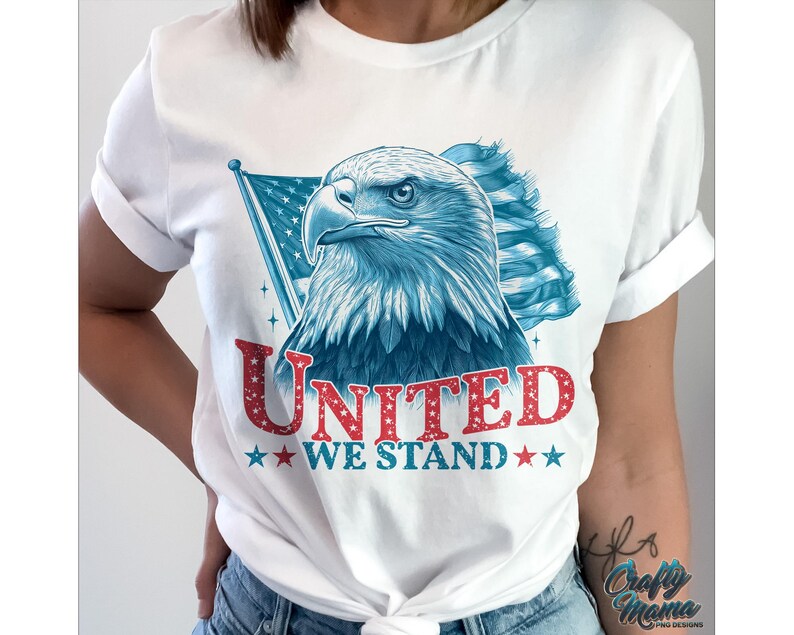 May include: White t-shirt featuring a blue and red American flag design and a bald eagle. The text "United We Stand" is printed in red glitter on the shirt.