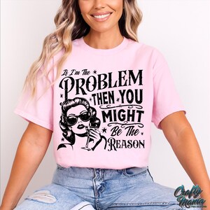 May include: Pink t-shirt with a black graphic print that says "If I'm the problem then you might be the reason". The graphic also features a woman with sunglasses and a drink.