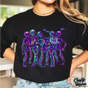 May include: A black sweatshirt with a graphic of five skeletons in neon colors dancing. The skeletons are wearing a variety of poses and expressions.