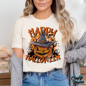 Peut inclure: Un t-shirt blanc avec un graphique d'une citrouille portant un chapeau de sorci&egrave;re et le texte "Happy Halloween".
