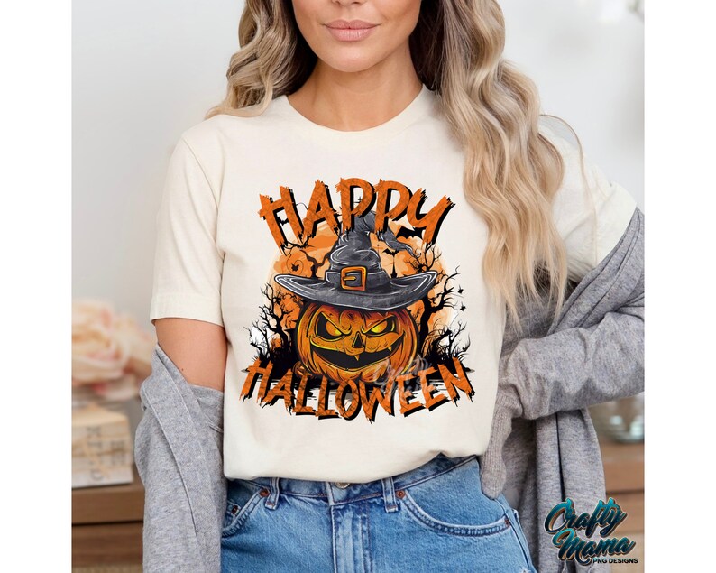 Peut inclure: Un t-shirt blanc avec un graphique d'une citrouille portant un chapeau de sorci&egrave;re et le texte "Happy Halloween".