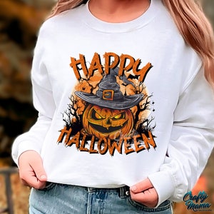 Peut inclure: Sweat-shirt blanc &agrave; manches longues avec un imprim&eacute; graphique d'une citrouille portant un chapeau de sorci&egrave;re et le texte "Happy Halloween".