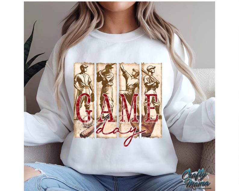 K&ouml;nnte beinhalten: Wei&szlig;es Sweatshirt mit einem Baseball-Motiv. Die Grafik zeigt vier Baseballspieler und die Worte "GAME DAY" in einem Vintage-Stil. Das Design verwendet Braun- und Rott&ouml;ne und erzeugt einen klassischen Sport-Look.