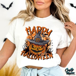 Peut inclure: T-shirt blanc avec un graphique de citrouille portant un chapeau de sorci&egrave;re et le texte "Happy Halloween".