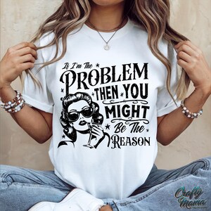 May include: White t-shirt with a black graphic print that says "If I'm the problem then you might be the reason". The graphic also features a woman with a cocktail.