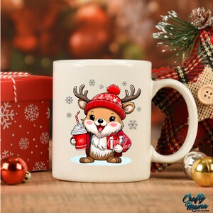 May include: White ceramic mug with a cartoon reindeer wearing a red hat and holding a red cup. The reindeer is surrounded by snowflakes.