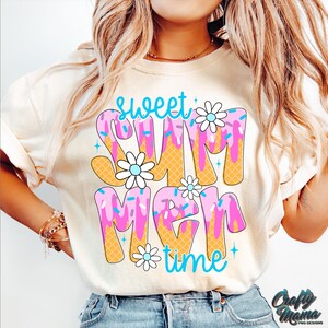 Pu&ograve; includere: Una maglietta bianca con un design grafico che dice "Sweet Summer Time" in un font di gelato colorato e gocciolante con codette e fiori.