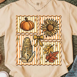 Puede incluir: Camiseta beige con un gr&aacute;fico tem&aacute;tico de oto&ntilde;o. El dise&ntilde;o incluye una calabaza, un girasol, ma&iacute;z, un lazo y hojas de oto&ntilde;o, todo dentro de marcos decorativos. La camiseta tiene una etiqueta Comfort Colors.