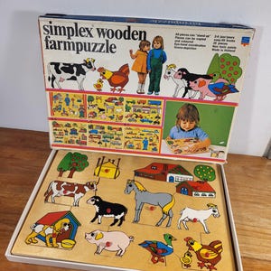 Puede incluir: Un rompecabezas de granja de madera con piezas coloridas de animales y temas de granja. El rompecabezas incluye una vaca, un caballo, un cerdo, un pato y una gallina. La caja dice "simplex wooden farmpuzzle".