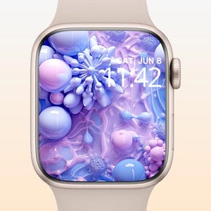 May include: A close-up of a smartwatch with a cream-colored band and a digital display. The screen shows a vibrant, abstract design with blue, pink, and purple spheres and floral shapes. The time displayed is 11:42, and the date is Saturday, June 8.