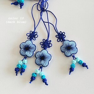Pu&ograve; includere: Ornamenti floreali ricamati blu scuro con cordoncini e perline abbinate. Il testo "color 10 (dark blue)" &egrave; visibile. Gli ornamenti presentano un motivo floreale con cuciture intricate e un bordo bianco. Le perline includono sfumature di blu.