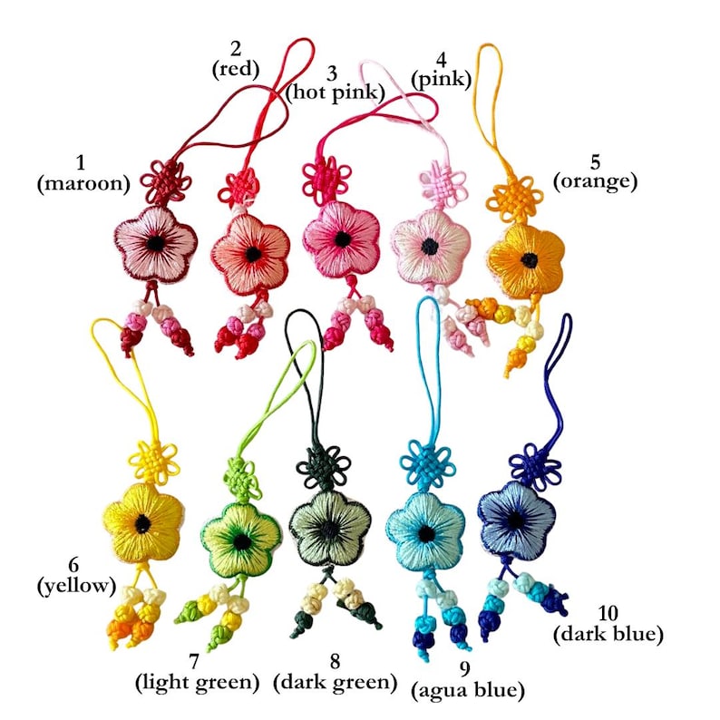 Pu&ograve; includere: Una collezione di dieci ornamenti ricamati a forma di fiore, in vari colori: marrone scuro, rosso, rosa acceso, rosa, arancione, giallo, verde chiaro, verde scuro, blu acqua e blu scuro. Ogni ornamento ha un anello per appenderlo.