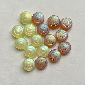 May include: A collection of 16 iridescent glass beads with a swirl design. The beads are in shades of yellow and orange.