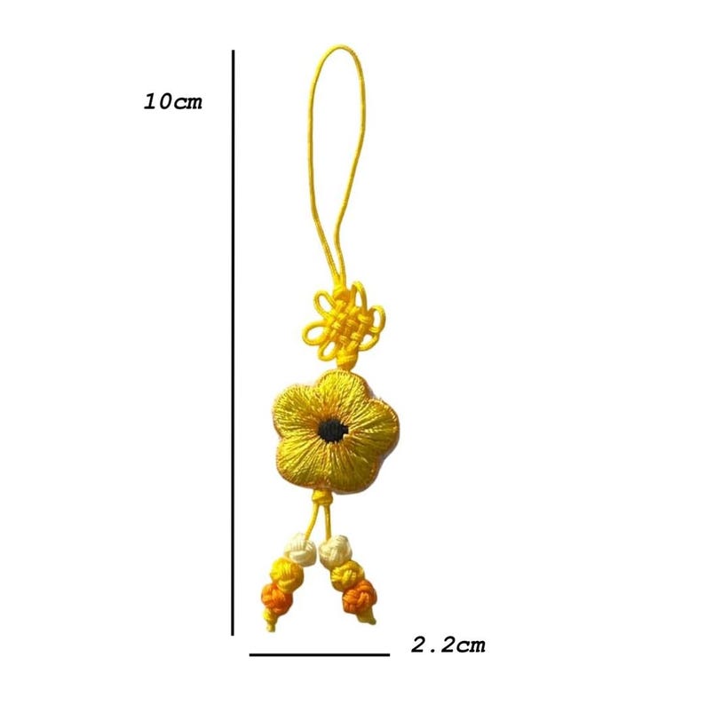 Pu&ograve; includere: Un ciondolo a forma di fiore ricamato giallo, lungo 10 cm e largo 2,2 cm. Il ciondolo presenta un fiore con un centro nero, un nodo decorativo e perline pendenti gialle, arancioni e bianche.