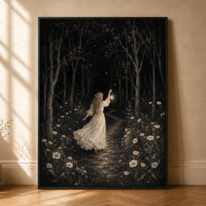 May include: A framed wall art print depicting a person in a long white dress walking along a dark forest path at night. The person holds a glowing lantern, illuminating white flowers along the trail, with tall trees and faint stars in the background.
