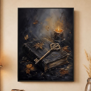 May include: A framed wall art print featuring a dark, weathered book with an ornate gold key resting on its cover. A lit candle in a small holder sits behind the book, casting a warm glow. Scattered autumn leaves surround the objects on a dark surface.