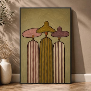 May include: A framed wall art print featuring three stylized figures standing side by side. Each figure wears a wide-brimmed hat and a long, vertically striped robe in shades of olive green, dusty pink, and muted purple against a sage background.