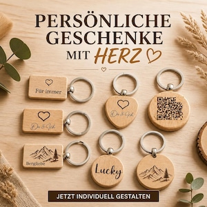 May include: A collection of light-colored wooden keychains in rectangular, heart, and circular shapes with metal rings. The keychains feature laser-engraved designs including hearts, mountain landscapes, the text "Du & Ich," "Für immer," "Lucky," and a QR code.