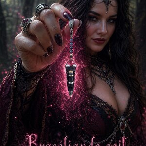 May include: A woman holds a black and silver pendulum with purple beads, surrounded by pink energy. She wears dark clothing and jewelry, with the text "Brocéliande soil" at the bottom. The image has a mystical, fantasy theme.