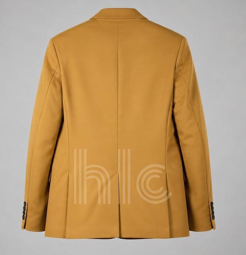 May include: Mustard-colored blazer with a classic design. The back view shows a tailored fit, notched lapels, and buttoned cuffs. The blazer has a two-button closure and a vent at the back. The image also shows the text "hlc" in a vertical pattern.