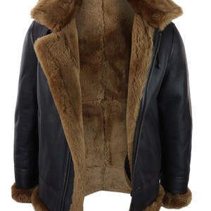 May include: A black leather jacket with a brown shearling lining and collar. The jacket features a zip closure and brown fur trim on the cuffs and collar. The jacket is open, showing the warm interior.