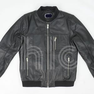 Puede incluir: Chaqueta bomber de cuero negro con cremallera, cuello, puños y dobladillo de canalé. Cuenta con dos bolsillos verticales con cremallera en el pecho y dos bolsillos laterales. Diseño clásico y estilizado.