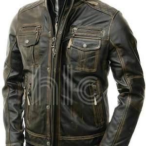 Puede incluir: Chaqueta de cuero marrón desgastado con múltiples bolsillos y cremalleras. La chaqueta presenta un diseño de hombro acolchado y un cuello alto. El cuero tiene una apariencia vintage desgastada.