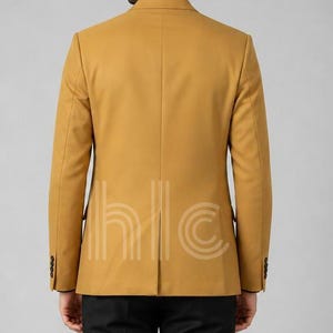 May include: Mustard yellow blazer with a two-button closure and black buttons. The back of the blazer is visible, showing a tailored fit and a vent at the bottom. The blazer has a classic, formal style.