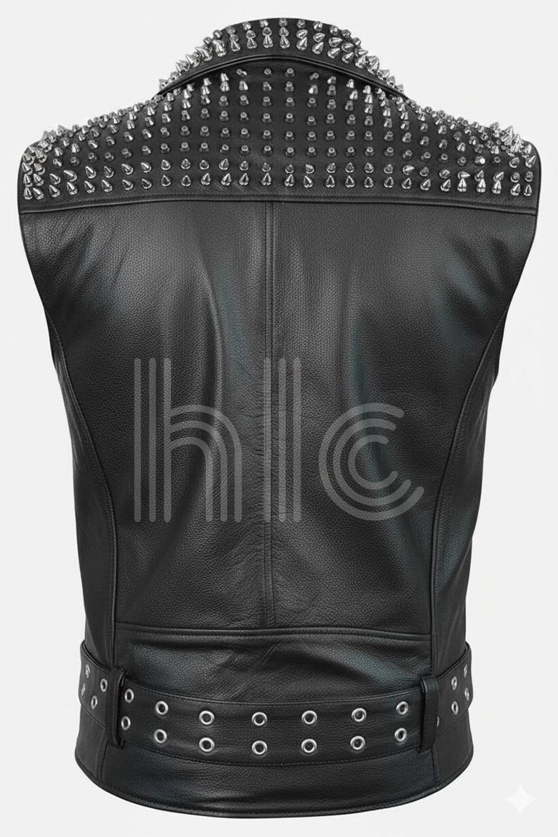 May include: Black leather vest with silver cone studs on the shoulders. The vest has a belt with silver grommets at the waist. The back of the vest is visible, showing the stitching and design.