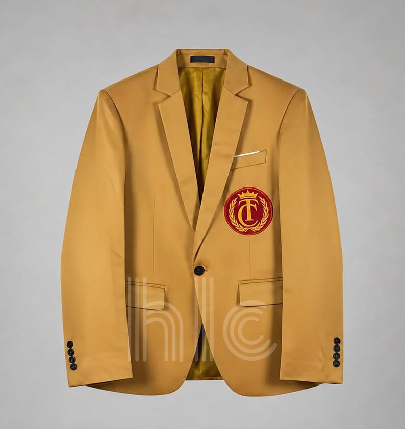 May include: Mustard yellow blazer with a classic notched lapel, a single-button closure, and a small pocket on the chest. The blazer features a red and gold embroidered crest on the left chest and four buttons on each cuff. The interior lining is a golden yellow.